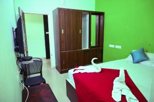 a bedroom with a bed with a red blanket at Royal Rock INN in Harihar +1 photo