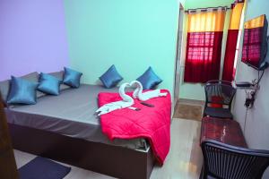 a bed with a red blanket and a chair in a room at Royal Rock INN in Harihar