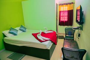 a bedroom with a bed with two swans on it at Royal Rock INN in Harihar