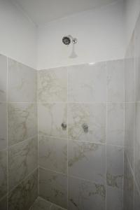 a bathroom with a shower with marble tiles at Hotel El Rincón in San Francisco del Rincón