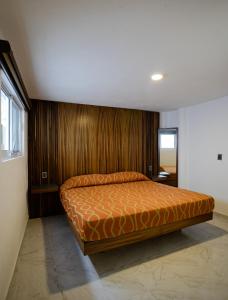 a bedroom with a bed with a wooden wall at Hotel El Rincón in San Francisco del Rincón