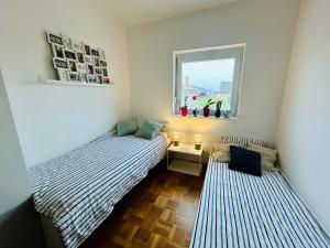 two beds in a small room with a window at Apartma VitaMia in Ankaran