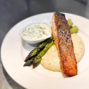 a plate of food with fish and asparagus and a sauce at La Sapinette in Val-David