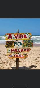 um sinal na praia com o oceano ao fundo em La petite maison em Portimão