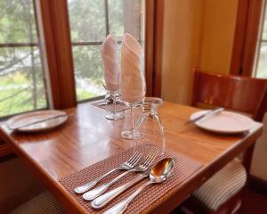 a wooden table with plates and silverware on it at La Sapinette in Val-David