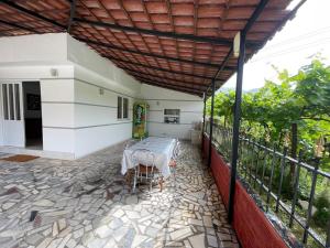 eine Terrasse mit Tisch und Stühlen auf einem Balkon in der Unterkunft Isufi House in Delvinë