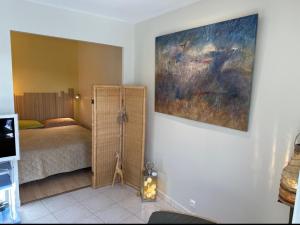 ラ・ボールにある3Très Beau logement, idéalement situé , Plages, Port & Vélo à Dispのベッドと壁に絵が飾られた寝室