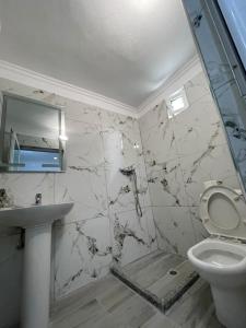 ein Badezimmer mit Toilette und Waschbecken in der Unterkunft Isufi House in Delvinë + 17 Fotos