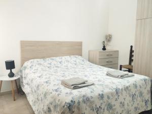 a bedroom with a bed with a blanket and a dresser at La Mata apartment on the first line in La Mata