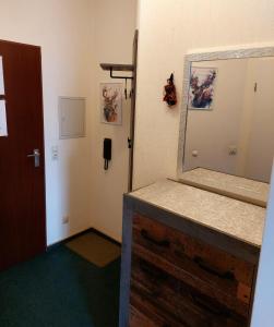 La salle de bains est pourvue d'un miroir et d'une commode en bois. dans l'établissement Ferienwohnung Sweety Haus Sachsensteinblick, à Bad Sachsa