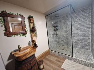 a bathroom with a shower with a wooden barrel sink at Gîte atypique NormandiK in Chailloué