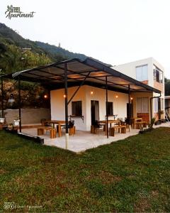 einem Pavillon mit Tischen und Stühlen vor einem Gebäude in der Unterkunft Green Apartment el prado in Girón
