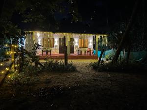 een huis verlicht in de nacht met lichten bij Marari Baiju's Homestay in Mararikulam