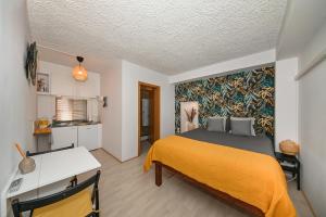 een slaapkamer met een bed met een gele deken bij The Lazy Monkey Hostel & Apartments in Zadar