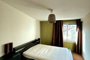 a bedroom with a bed and a window at Maison proche du centre de Paris calme et verdure in Villejuif