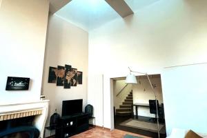 a living room with a fireplace and a staircase at Maison proche du centre de Paris calme et verdure in Villejuif