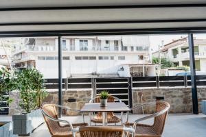 een patio met een tafel en stoelen op een balkon bij Filion Apartments Nafplio in Nafplio