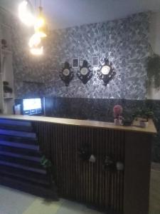 eine Bar mit Uhren an einer Wand und Treppen in der Unterkunft Safari Hotel in Lahore