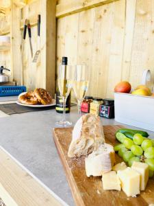 a cutting board with cheese and a glass of wine at Charming Lodge in Morpeth in Morpeth