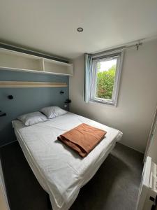 - une chambre avec un lit et une serviette dans l'établissement Camping le Moulin de la Salle, à Les Sables-dʼOlonne