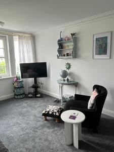 a living room with a chair and a table at Central St Andrews 2 bed apartment in St. Andrews