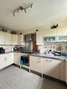 cocina grande con armarios y electrodomésticos blancos en Central St Andrews 2 bed apartment, en St Andrews
