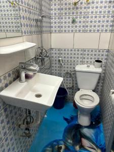 La salle de bains est pourvue d'un lavabo et de toilettes. dans l'établissement La Perle du Sahel avec clé personnel du portail, à Niamey