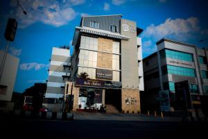 a building on a street with a blue sky at Four N Square Residency in Palakkad