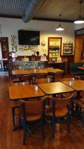 um restaurante com mesas e cadeiras de madeira e um balcão em The Bell Tolls em Turtletown