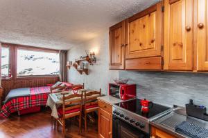 eine Küche mit einem Tisch und einem Bett in einem Zimmer in der Unterkunft Marcolski home in Breuil-Cervinia