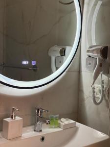 a bathroom sink with a mirror and a hair dryer at comfort rooms in Himare +71 photos
