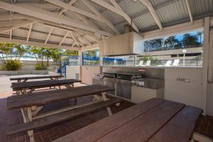 a kitchen with wooden benches and tables in it at Centrepoint Resort in Gold Coast