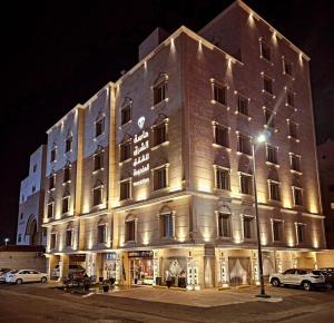 duży budynek z oświetleniem w nocy w obiekcie ماسة الشرق للوحدات السكنية w mieście Dżudda