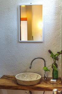ein Badezimmer mit einem Steinwaschbecken und einem Spiegel in der Unterkunft Hotel Manava in Brisas de Zicatela + 37 Fotos