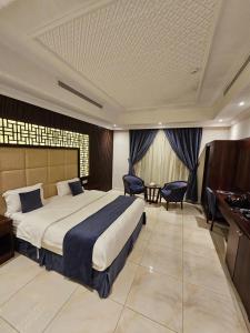 een hotelkamer met een groot bed en een bureau bij ماسة الشرق للوحدات السكنية in Jeddah
