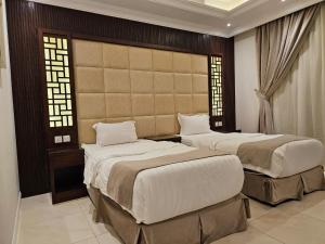 twee bedden in een kamer met twee ramen bij ماسة الشرق للوحدات السكنية in Jeddah