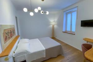 a white bedroom with a bed and a window at La Piazzetta in Morigerati