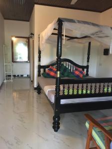 1 dormitorio con cama de madera en una habitación en Gems Garden Guest House, en Tangalle