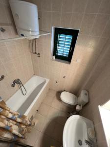 a bathroom with a tub and a toilet and a sink at Renome in Petrovac na Moru