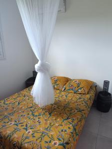 - une chambre avec un lit et un rideau dans l'établissement Location vacances Guadeloupe Gite et table d'hôtes Kaz a Klemence Anse-Bertrand, à Anse-Bertrand