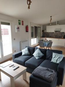 a living room with a blue couch and a table at Ático Entero con Habitación en Corella in Corella