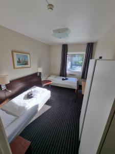 um quarto de hotel com duas camas e uma janela em Stord Folkehøgskule Sommarhotell em Stord