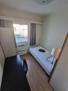 um quarto de hotel com uma cama e uma janela em Stord Folkehøgskule Sommarhotell em Stord