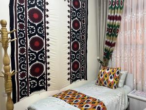 - une chambre dotée d'un lit avec un mur noir et blanc dans l'établissement Old Palace Hotel, à Samarcande