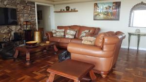 a living room with a leather couch and a table at Multiplex with a view in Durban