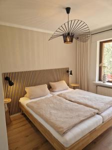 a bedroom with a large bed and a chandelier at Haus Daut FeWo mit Hallenbad in Willingen