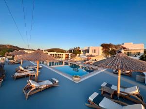 a large swimming pool with chairs and umbrellas at Anemoi Resort in Naousa