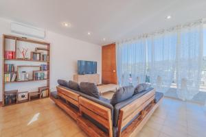 sala de estar con sofá y ventana grande en Casa William - Villa e 2 Dependance, en Porto Azzurro