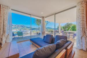 a living room with a blue couch and large windows at Casa William in Porto Azzurro