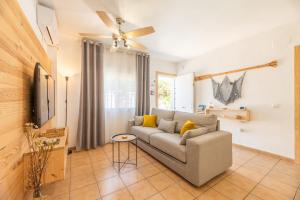 een woonkamer met een bank en een plafondventilator bij Apartamento Playa La Barrosa in Chiclana de la Frontera